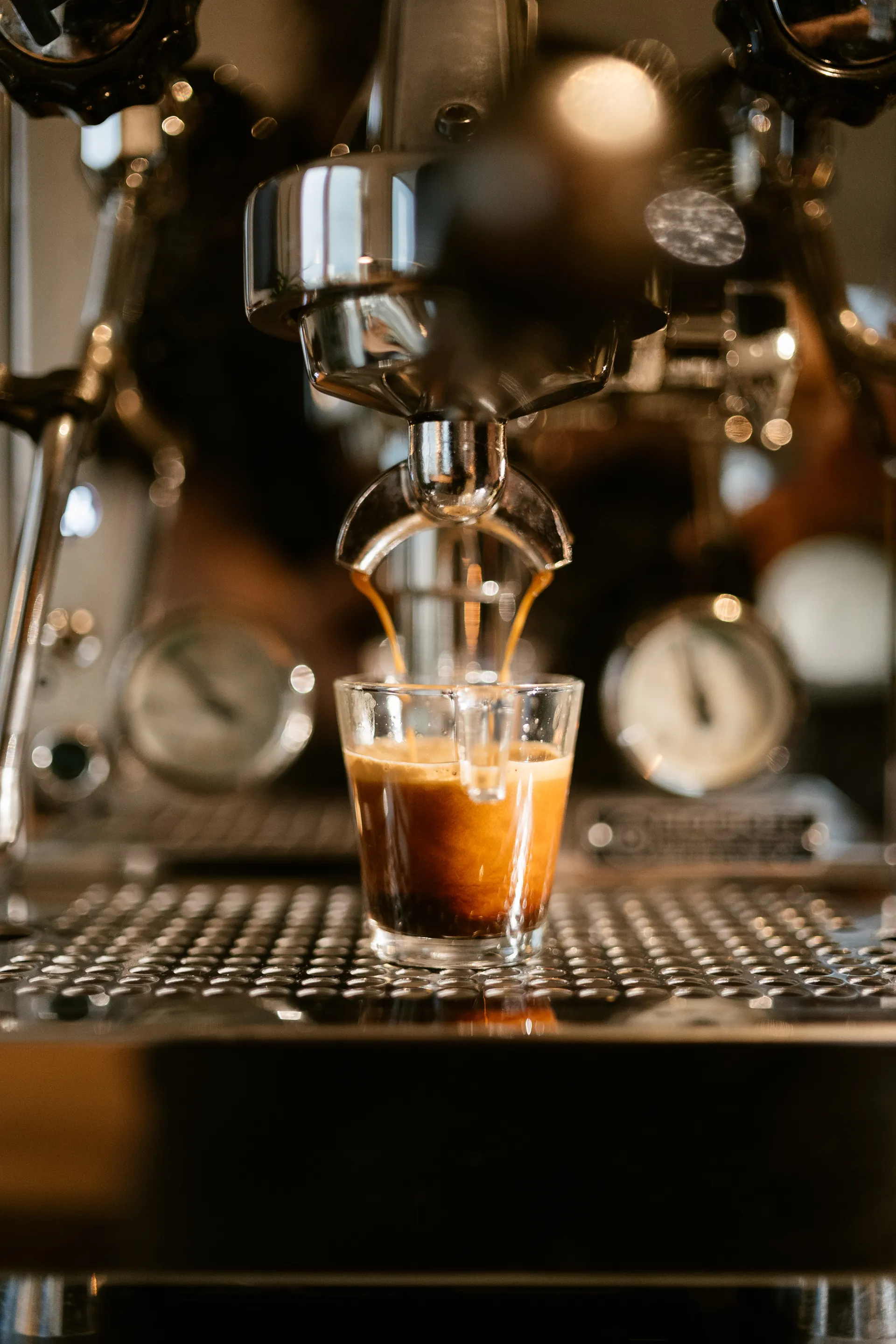 Espresso-Extraktion — goldener Kaffeestrahl fließt ins Glas